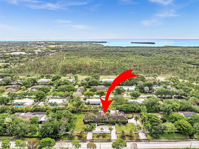 birds eye view of property with a water view and a view of trees