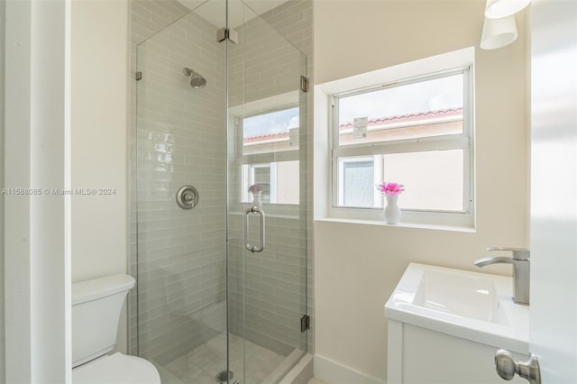 bathroom with an enclosed shower, vanity, and toilet