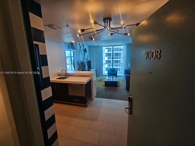 kitchen featuring light tile patterned floors, dark brown cabinetry, appliances with stainless steel finishes, and tasteful backsplash