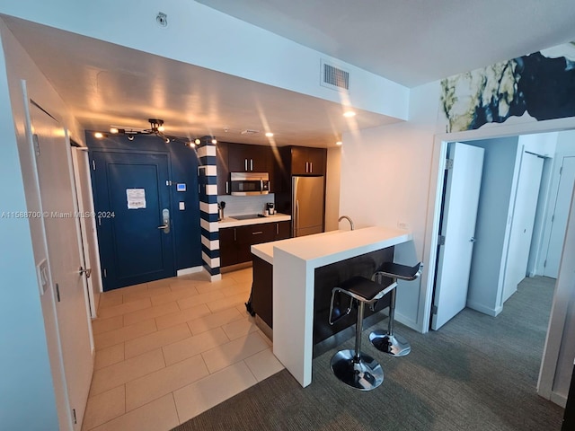 interior space with dark brown cabinets, light tile patterned floors, and sink