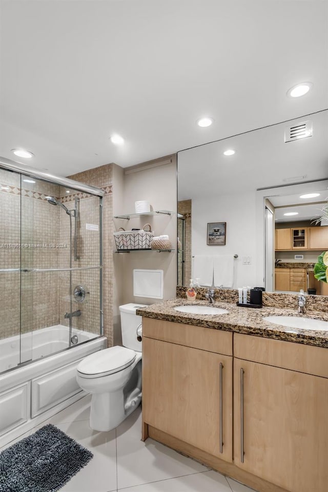 full bathroom with tile patterned flooring, vanity, toilet, and shower / bath combination with glass door