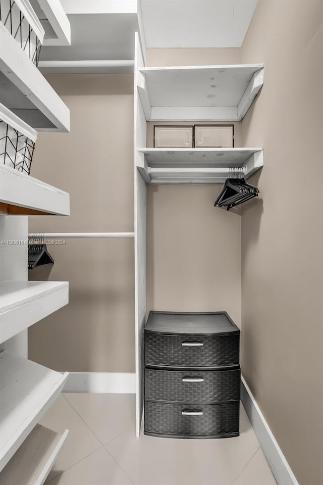 walk in closet with light tile patterned floors