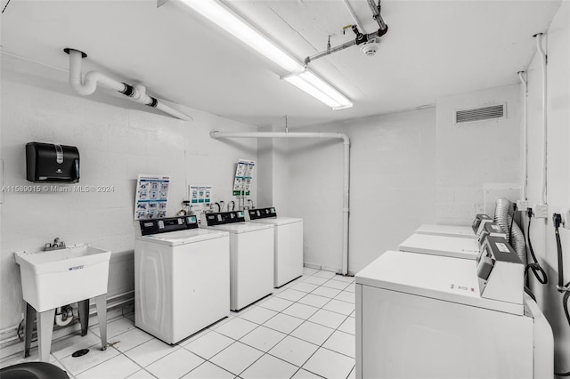 washroom featuring washing machine and dryer and light tile patterned floors