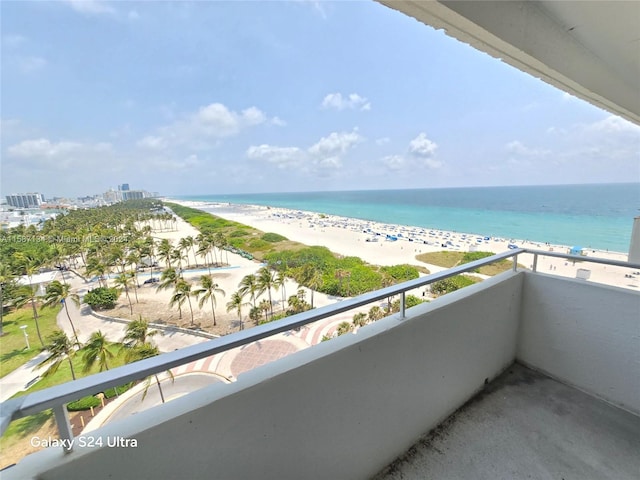 balcony featuring a view of the beach and a water view