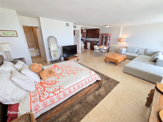 bedroom featuring tile floors and ensuite bathroom