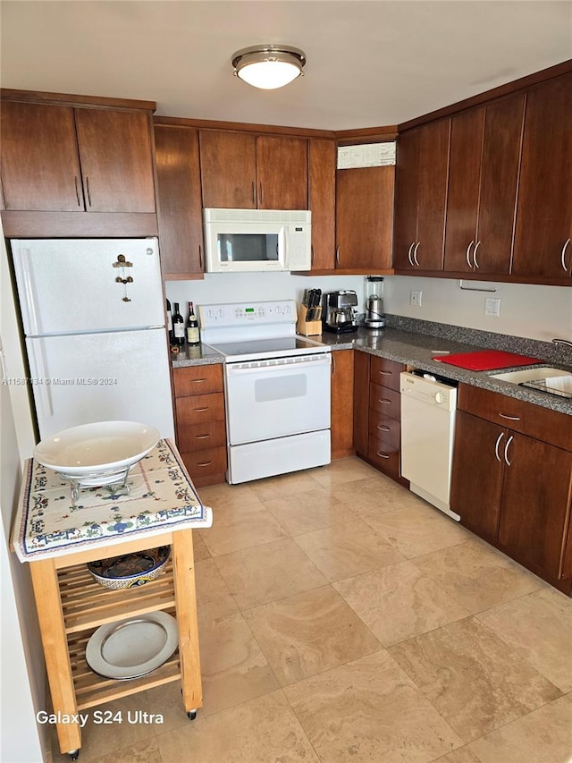 kitchen featuring sink, light tile flooring, and white appliances