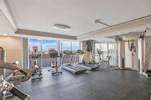 workout area with a wealth of natural light, a textured ceiling, and a wall of windows