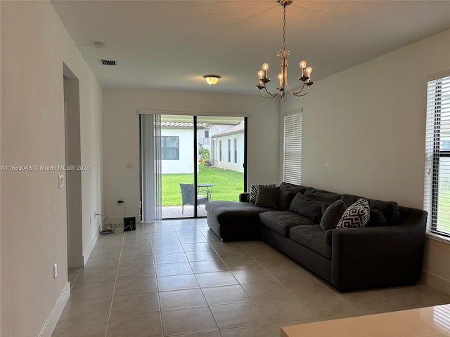 living room with a wealth of natural light, a chandelier, and light tile floors