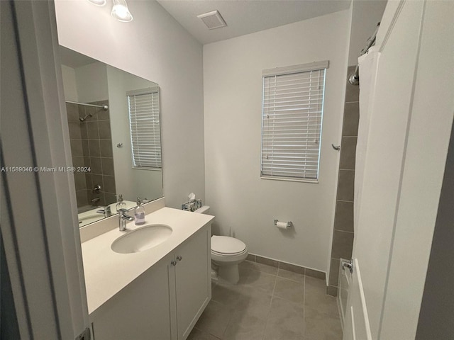 bathroom with tile floors, oversized vanity, and toilet