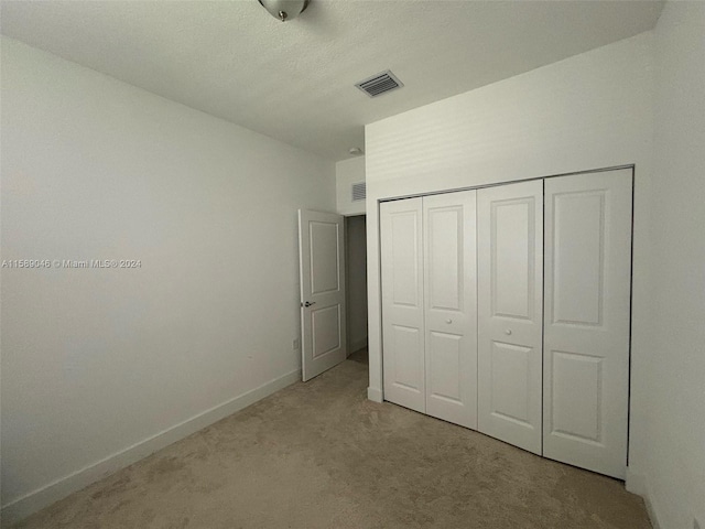 unfurnished bedroom featuring a closet and carpet