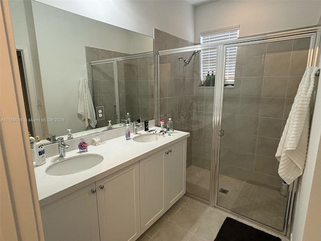 bathroom with walk in shower, dual sinks, vanity with extensive cabinet space, and tile floors