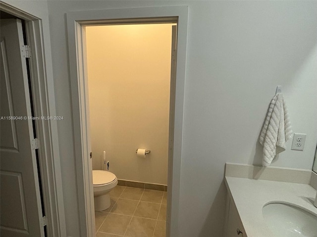 bathroom featuring tile floors, vanity, and toilet