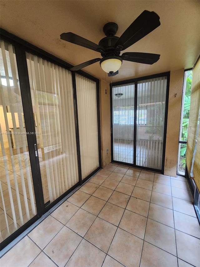 unfurnished sunroom featuring ceiling fan and plenty of natural light