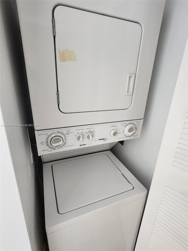 clothes washing area featuring stacked washer and dryer