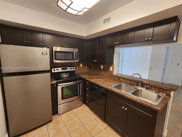 kitchen featuring sink, tasteful backsplash, light tile patterned floors, stainless steel appliances, and kitchen peninsula