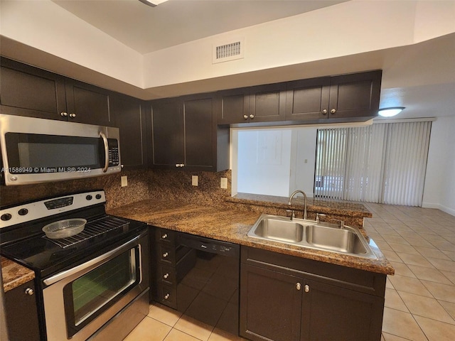 kitchen featuring appliances with stainless steel finishes, decorative backsplash, dark brown cabinetry, sink, and light tile patterned floors