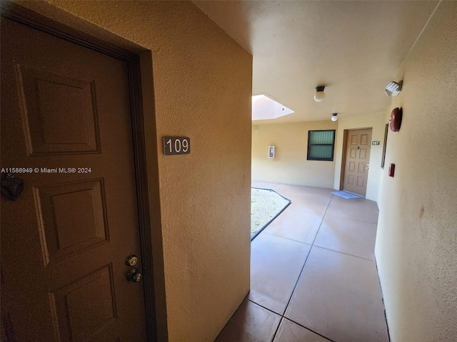 hall featuring light tile patterned floors