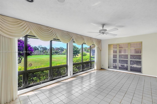 unfurnished sunroom with ceiling fan