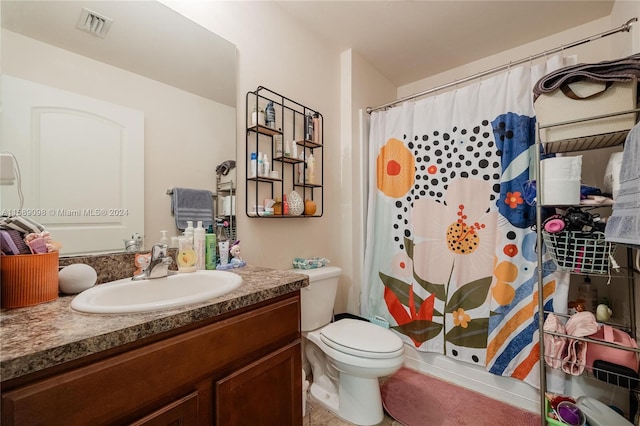 bathroom featuring vanity with extensive cabinet space and toilet