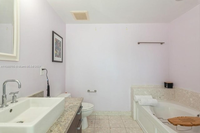 bathroom featuring tile floors, a washtub, toilet, and large vanity