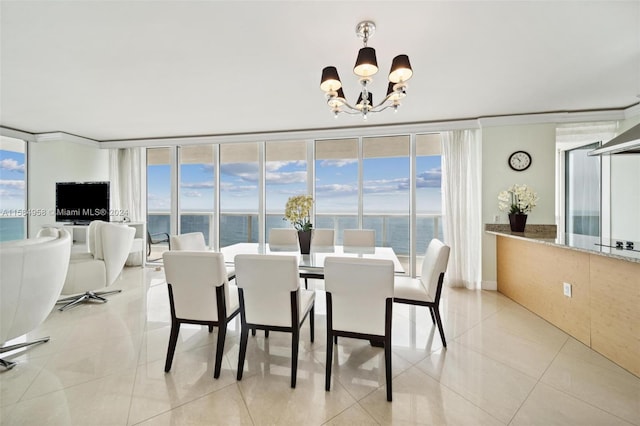 tiled dining room featuring an inviting chandelier and a water view