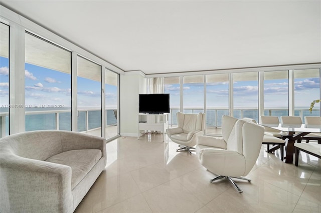 living room featuring light tile floors, a water view, and expansive windows