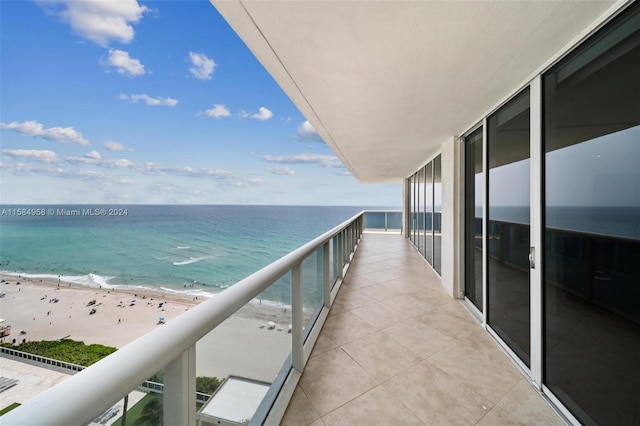 balcony featuring a beach view and a water view