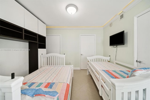 bedroom featuring crown molding and light tile floors