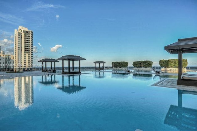 view of swimming pool with a dock and a water view