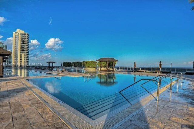 view of swimming pool featuring a patio and a gazebo