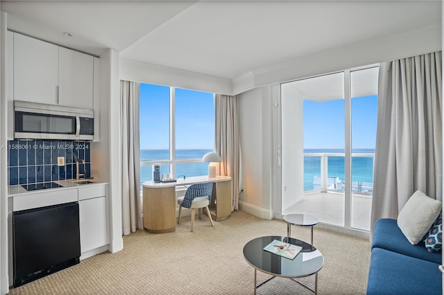 carpeted living room featuring a wealth of natural light and a water view