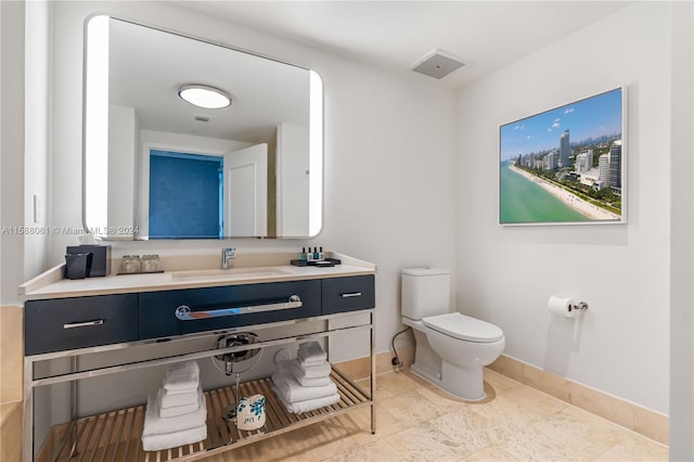 bathroom with tile floors, vanity, and toilet