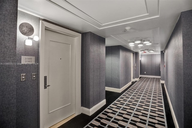 hallway featuring dark tile flooring