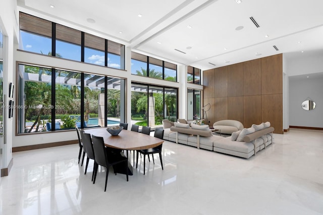 dining room with wood walls and a towering ceiling