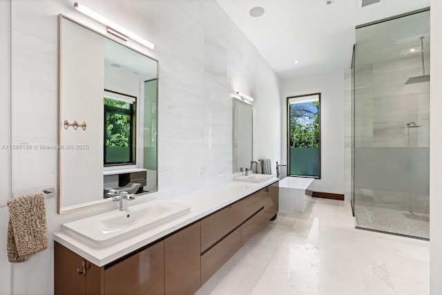 bathroom featuring a shower with door and vanity