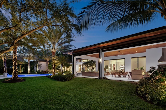 rear view of house with a lawn and a patio