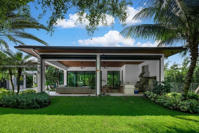 back of property with outdoor lounge area, ceiling fan, a yard, and a patio area