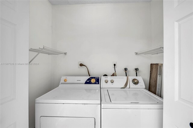 clothes washing area with washing machine and dryer