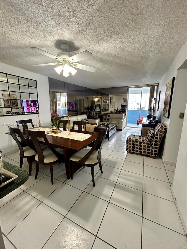 tiled dining room featuring a textured ceiling, ceiling fan, and a wall of windows