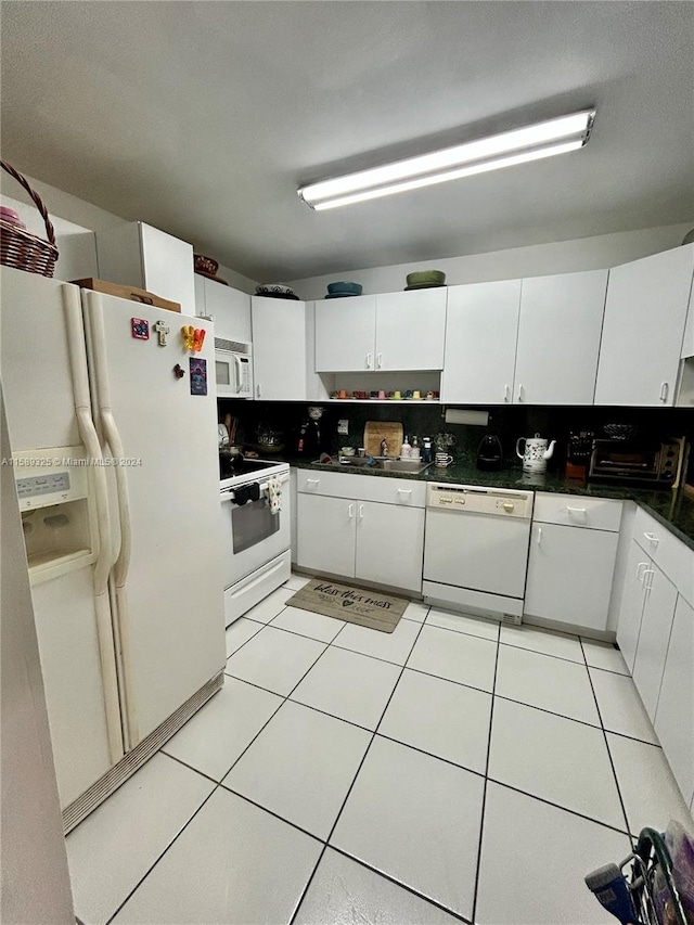 kitchen featuring white cabinets, white appliances, and light tile flooring