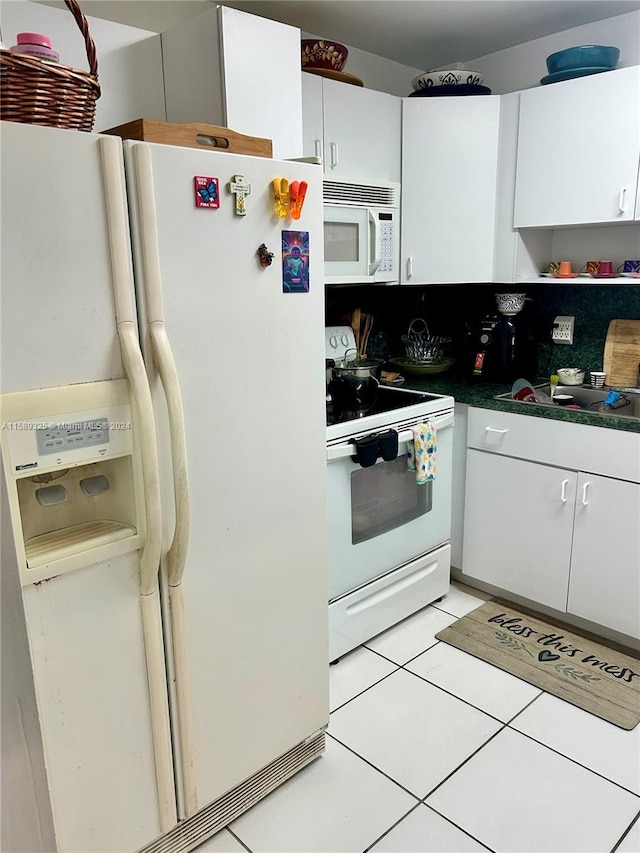 kitchen featuring white appliances, sink, white cabinetry, and light tile floors