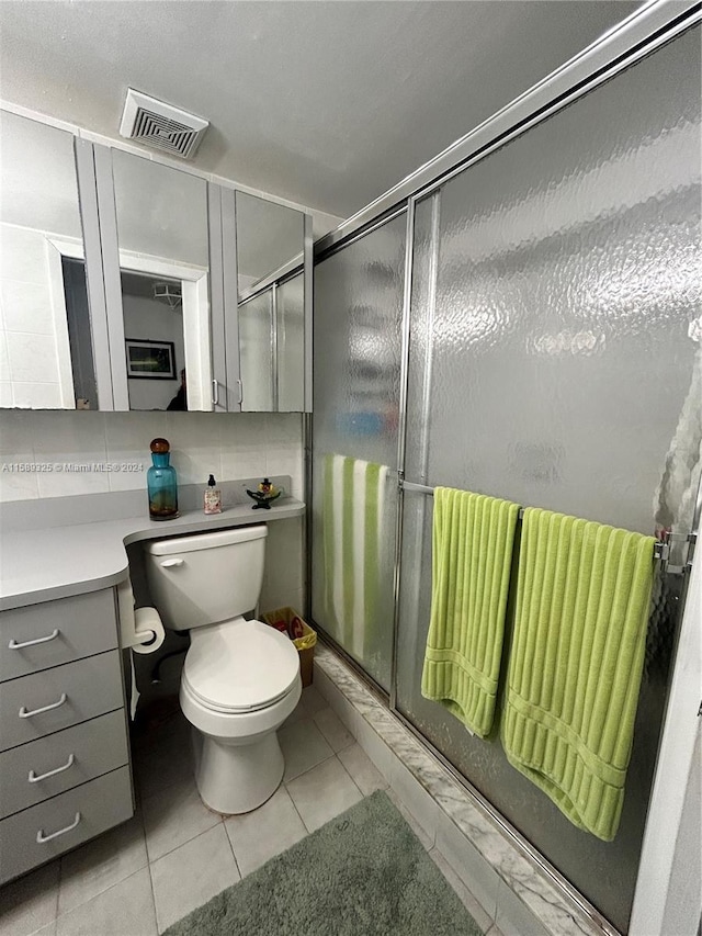 bathroom featuring backsplash, toilet, tile floors, an enclosed shower, and vanity