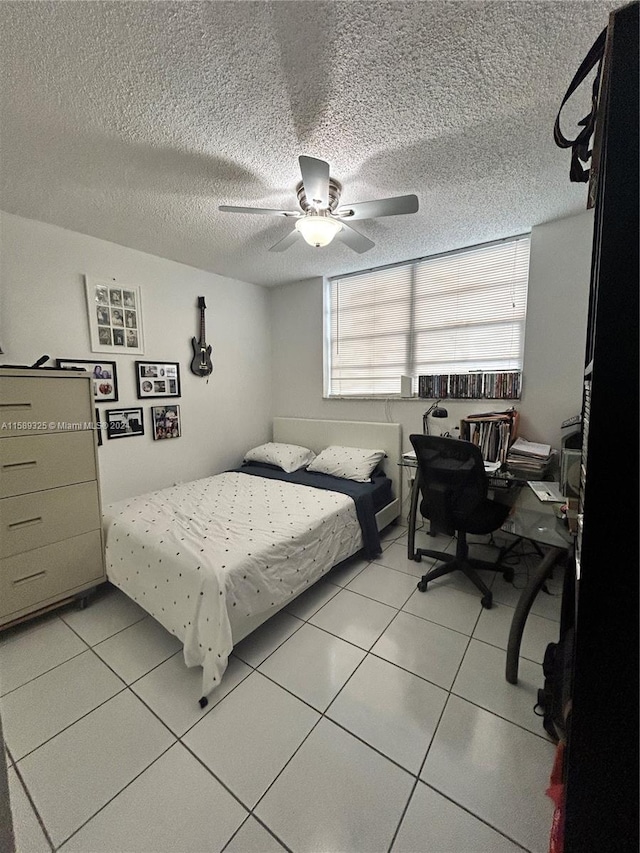 tiled bedroom with ceiling fan and a textured ceiling