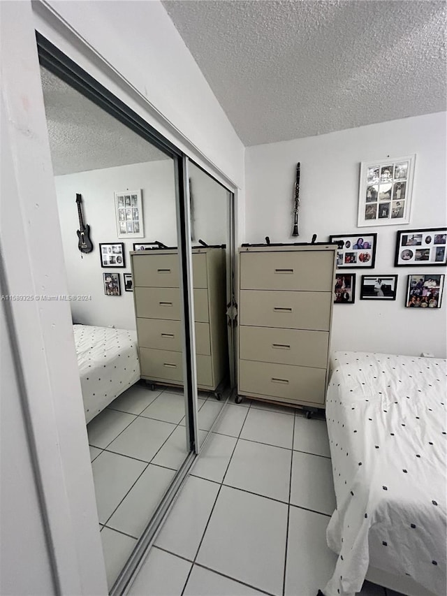 tiled bedroom featuring a closet and a textured ceiling