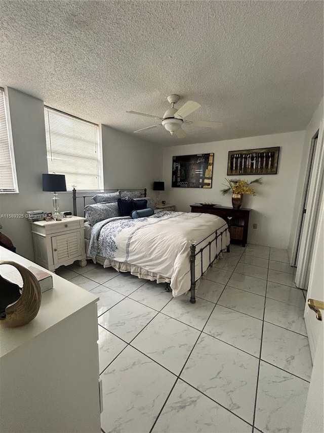 tiled bedroom with a textured ceiling and ceiling fan