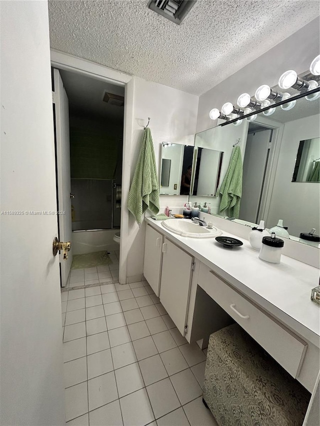 full bathroom featuring tile flooring, vanity, a textured ceiling, toilet, and shower / bathtub combination