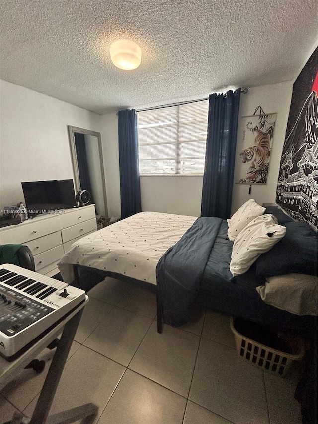 tiled bedroom featuring a textured ceiling