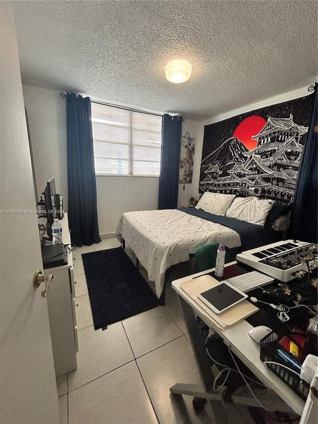 bedroom with a textured ceiling and light tile floors