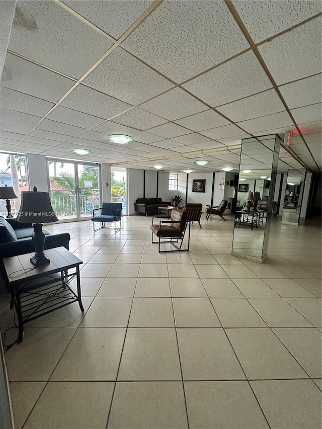 living room featuring tile flooring and a drop ceiling