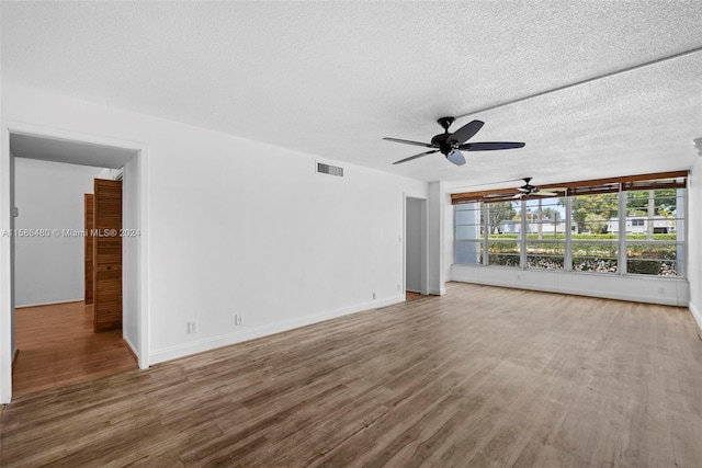 unfurnished room with wood-type flooring, ceiling fan, and a textured ceiling